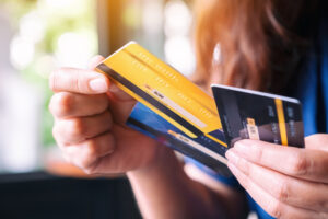 Closeup image of a young adult holding and choosing credit card to use