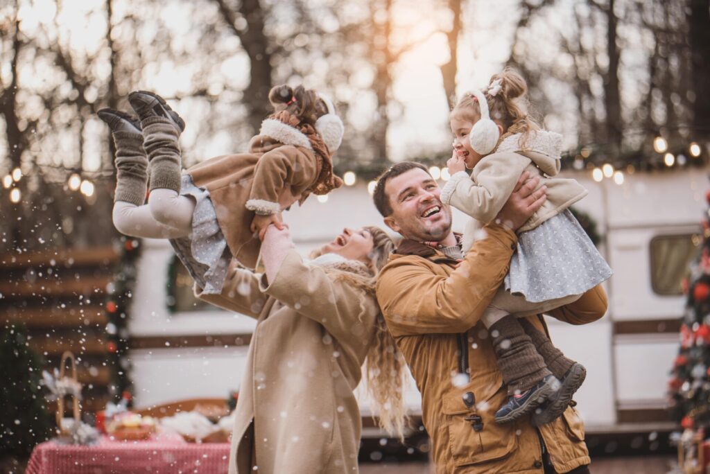 A joyful family playing together in the snow, building a snowman and enjoying the winter wonderland around them.