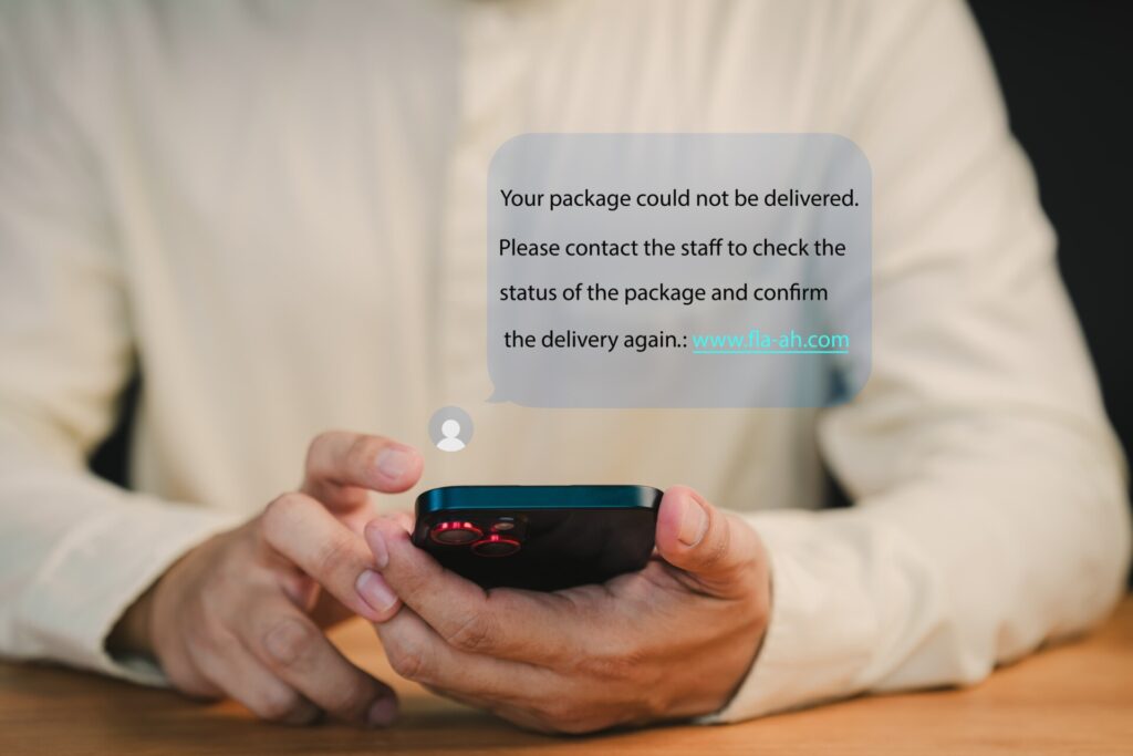 Person holds a smartphone displaying a notification about a failed package delivery. This message user to contact support and confirm delivery. Fake Text message SMS scam or phishing concept