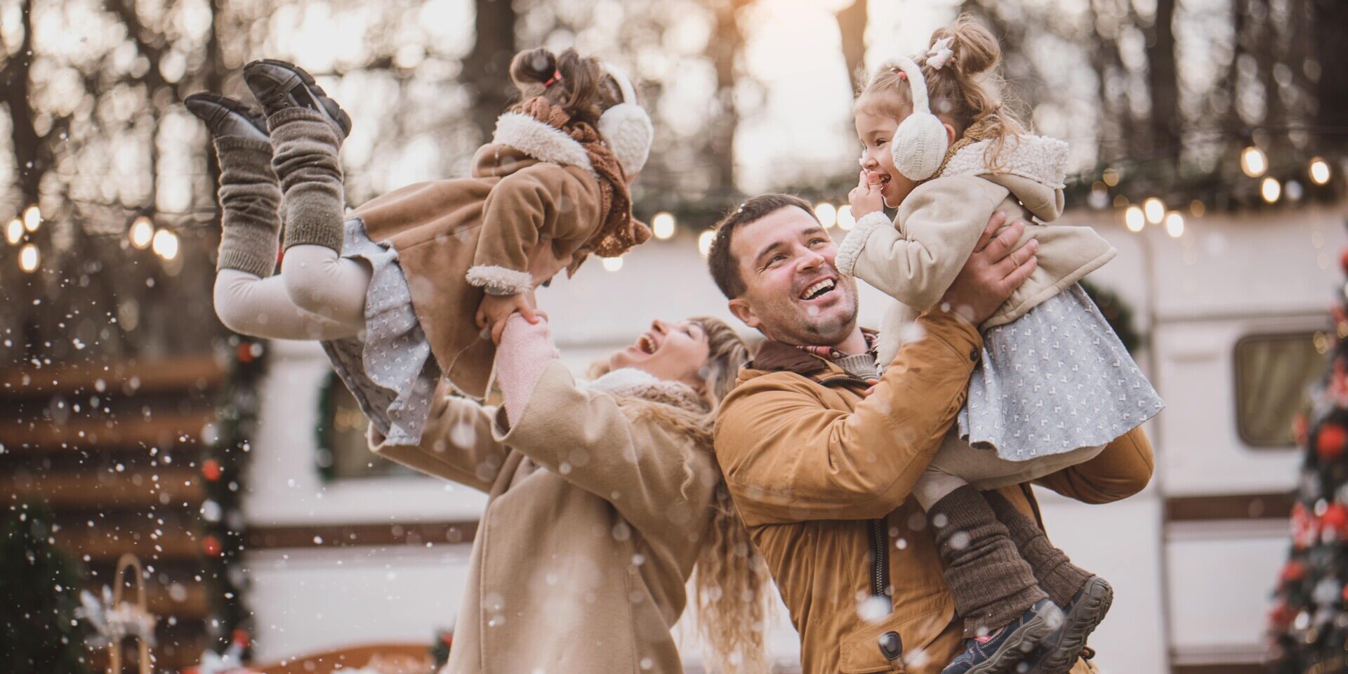 A joyful family playing together in the snow, building a snowman and enjoying the winter wonderland around them.