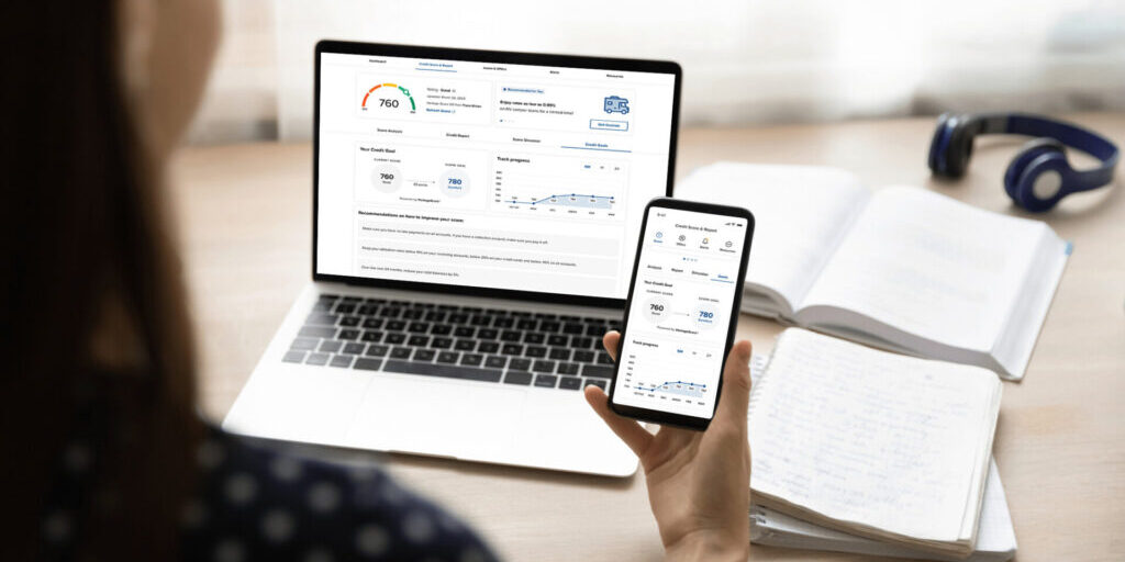 An individual engaging with a mobile app and computer designed to track their credit score and monitor their credit report effectively.